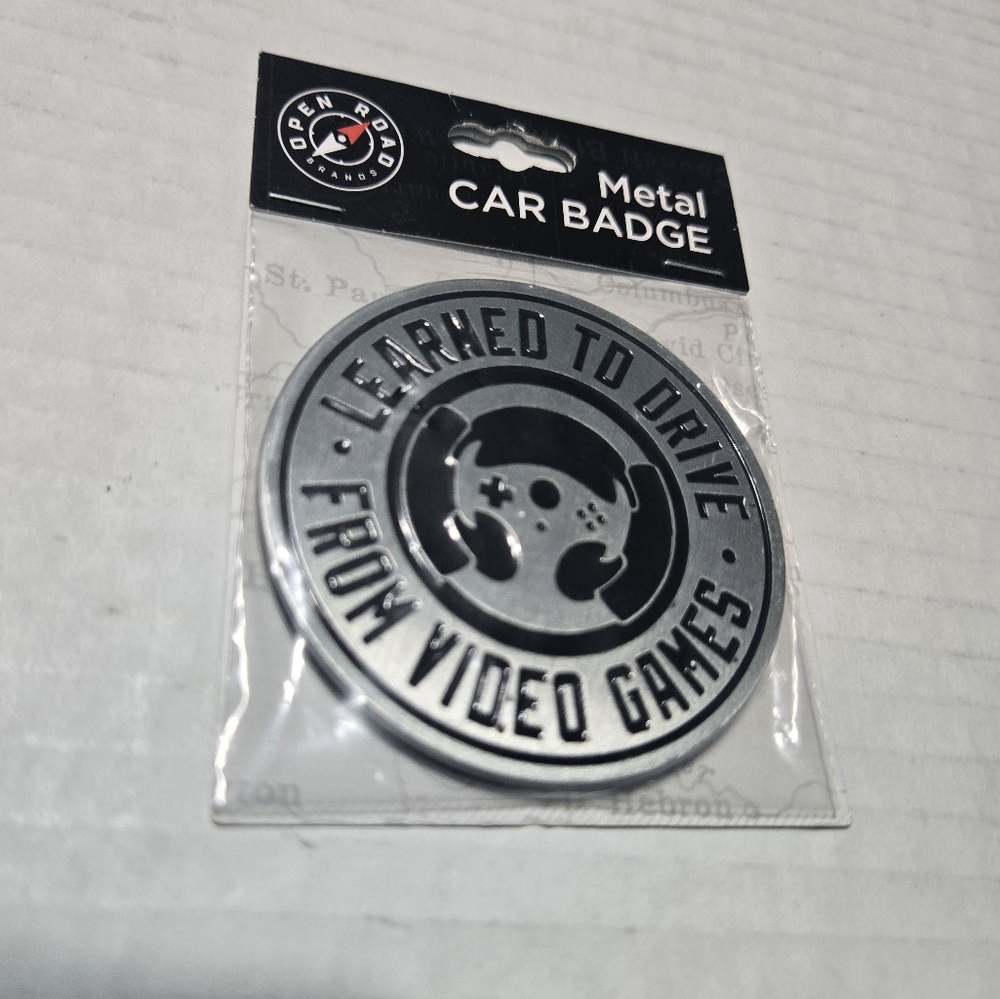 Metal Car Badge Car Emblem says "LEARNED TO DRIVE FROM VIDEO GAMES"